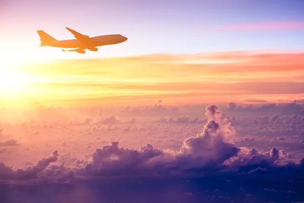 Airplane in the sky at sunrise — Stock Photo, Image
