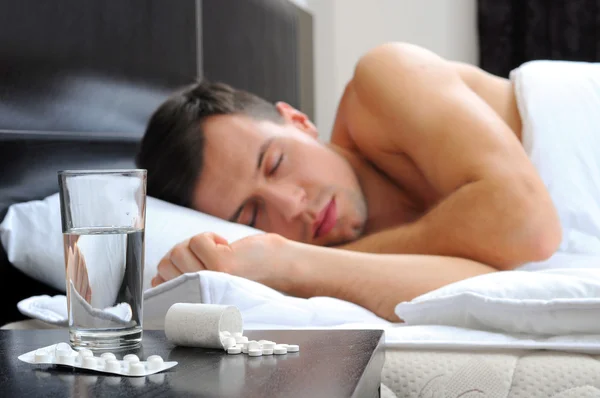 Hombre durmiendo - pastillas en la mesa de la cama — Foto de Stock