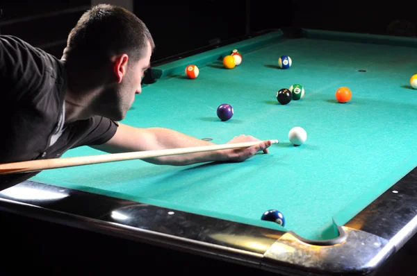 Man spela snooker i en mörk klubb — Stockfoto