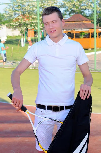 Jugador de tenis posando frente a una pista de tenis —  Fotos de Stock