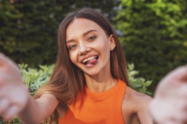 Bir yaz parkında bankta oturmuş video konferansı sırasında sohbet eden güzel bir kız..