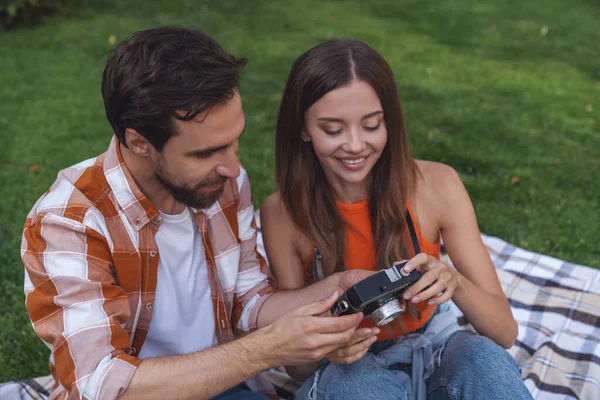 Joven Pareja Alegre Sentada Una Manta Parque Durante Picnic Tomando — Foto de Stock