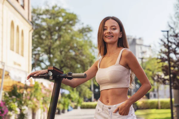 Alegre Joven Hermosa Chica Mientras Monta Scooter Eléctrico Una Calle — Foto de Stock