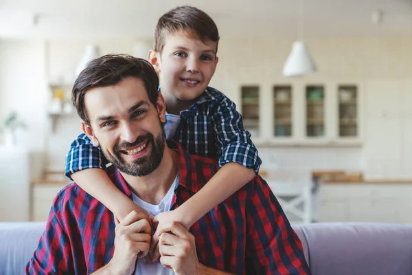 Kleiner Glücklicher Junge Umarmt Seinen Vater Hals Während Hause Auf — Stockfoto