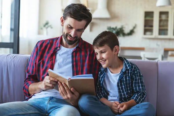 Glücklicher Kleiner Junge Und Sein Gut Gelaunter Vater Lesen Ein — Stockfoto