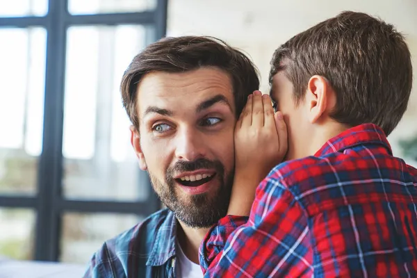 Little Boy Secretly Whispers Something His Dad Ear Home Living — Stock Photo, Image