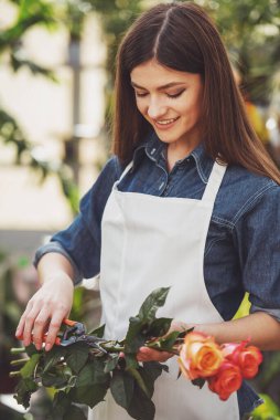Genç kadın çiçekçi kesim portresi dükkanda maşa ile yükseldi.