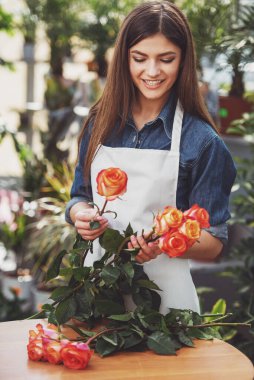 Çiçekçide çalışan genç kadın çiçekçinin portresi.
