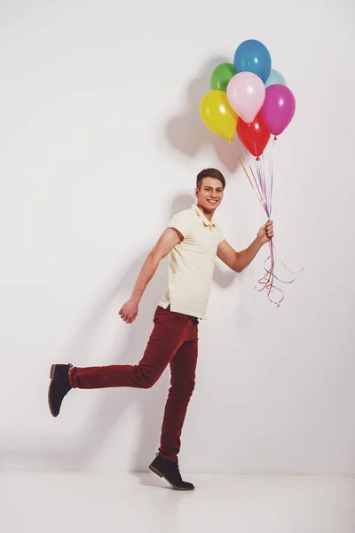 Giovane Uomo Con Palloncini Colorati Piedi Sfondo Grigio — Foto Stock