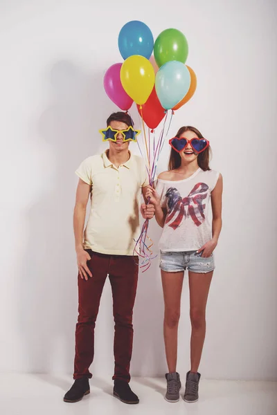 Cheerful Young Couple Standing Funny Glasses Holding Colorful Balloons — Stock Photo, Image