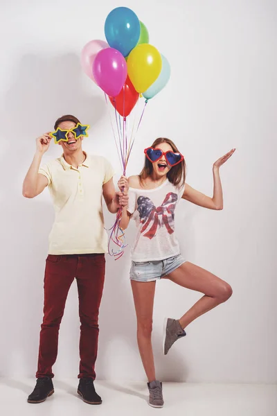 Fröhliches Junges Paar Mit Lustigen Gläsern Und Bunten Luftballons — Stockfoto