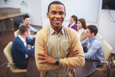 Confident businessman is standing in office on background of colleagues. clipart