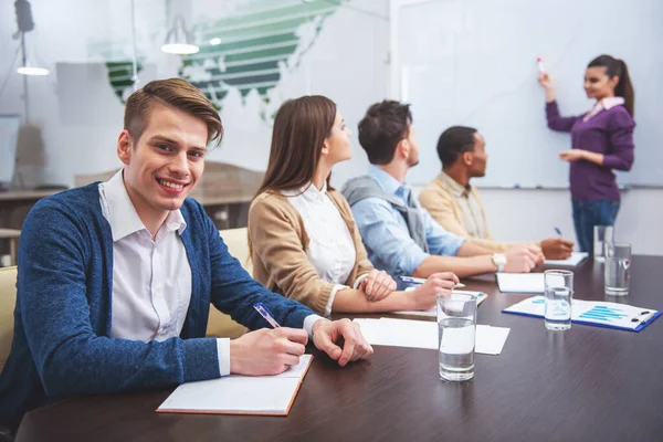 Confident business woman in meeting at office with team.