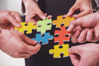 Bulmaca parçalarını bir araya getirmek isteyen iş adamlarının yakın çekim.