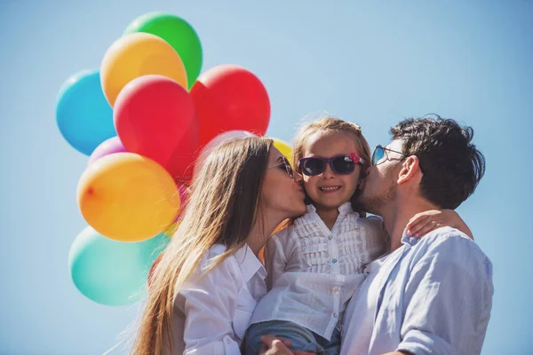 Jovens Pais Atraentes Com Balões Beijando Sua Filha Bochecha — Fotografia de Stock