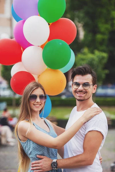 Casual Birbirine Bağlar Parlak Helyum Balonları Tutan Genç Çift Giymiş — Stok fotoğraf