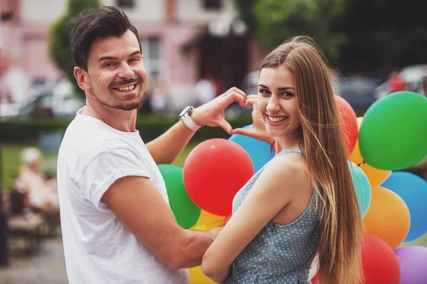 Jeune Couple Charmant Avec Des Ballons Façonnant Symbole Cœur Avec — Photo