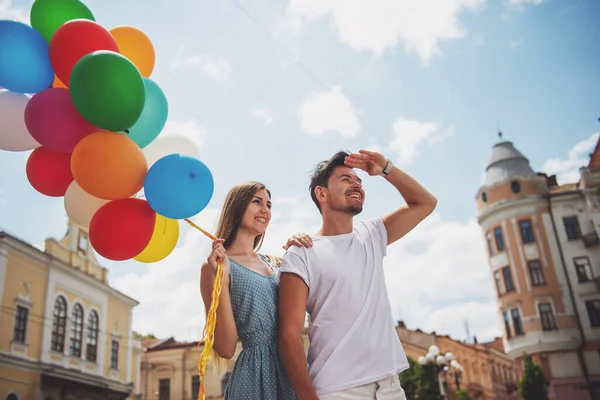 可爱的夫妻走在街上与气球和视线 — 图库照片