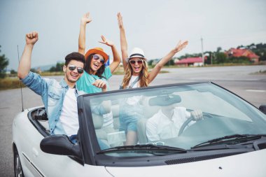 İn arkadaş grubu ile beyaz cabriolet seyahat ve having fun güneş gözlüğü.