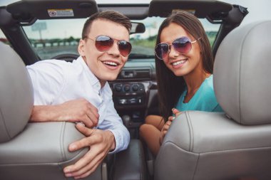 Güzel çift güneş gözlüğü sittling üstü açılabilir ve kameraya bakıyor. Arkadan Görünüm.