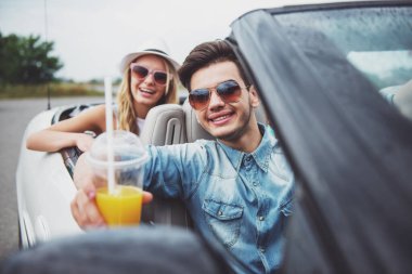 Cabriolet vurdu. Kameraya bakarak ve gülümseyen suyu gözlük ile iki genç arkadaşlar.