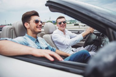 Yakışıklı çocuklar Cabriolet tarafından kırsal sürüş sırasında sürüş. Yan görünüm.