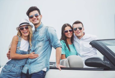 Tatil içinde iki Genç çiftler. İlk çift ayakta cabriolet ve arkasında ikinci Çift.