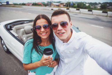 Selfie karşı cabriolet alarak güneş gözlüklü genç güzel Çift.