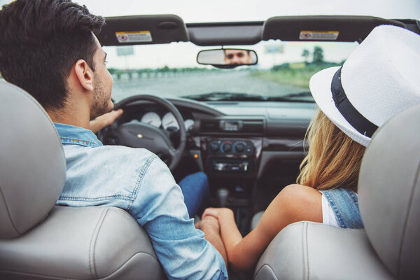 Couple traveling on the cabriolet. Back view. Close-up.