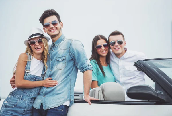 Tatil içinde iki Genç çiftler. İlk çift ayakta cabriolet ve arkasında ikinci Çift.