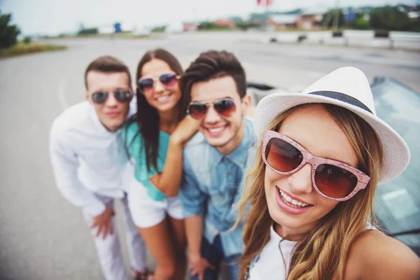 Kameraya bakarak ve gülümseyen cabriolet yakınındaki iki güzel Çift.