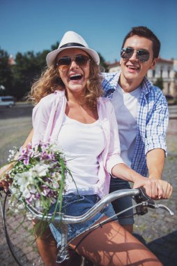 Çift birlikte şehrin sokak üzerinde bisiklet sürme güneş gözlüğü portresi.