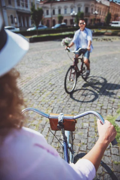 女性帽子とお互いに自転車に乗って花を持つ男 — ストック写真