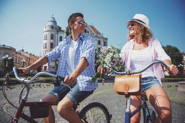 性格开朗白之恋人骑自行车在城市大街上 期待着彼此的太阳镜 — 图库照片