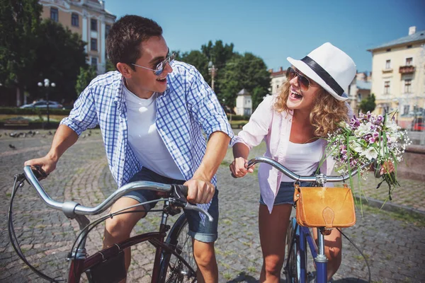 白之恋人骑自行车在城市大街上 看不到彼此开心的太阳镜 — 图库照片