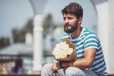 Buket çiçek ile yakışıklı genç kız arkadaşı için bekliyor.