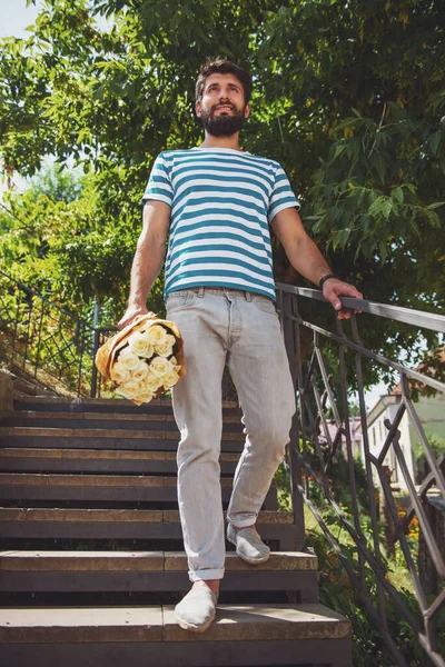 Buket çiçek ile yakışıklı genç kız arkadaşı için bekliyor.