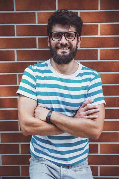 Yakışıklı genç adam akıllı rahat kıyafet içinde poz ve kameraya bakıyor.