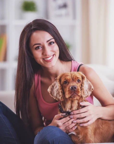 犬と幸せな若い女性がソファーに座っています — ストック写真