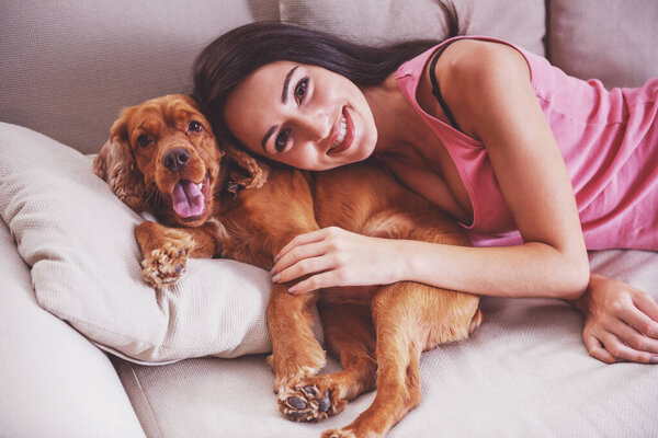 Молодая, привлекательная женщина играет с собакой дома
.