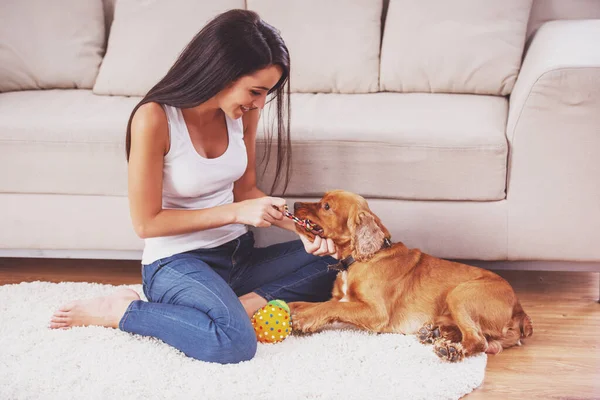 Счастливая Женщина Играет Собакой Сидящей Полу Дома — стоковое фото