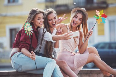 Üç güzel genç kadın açık havada bir doğum günü kutluyor