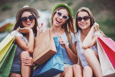 alışveriş, satış, mutlu insanlar ve Turizm kavramı - City alışveriş torbaları ile güneş gözlüğü üç güzel kız
