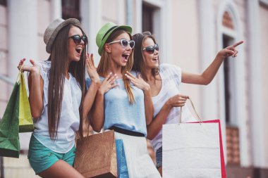 alışveriş, satış, mutlu insanlar ve Turizm kavramı - City alışveriş torbaları ile güneş gözlüğü üç güzel kız