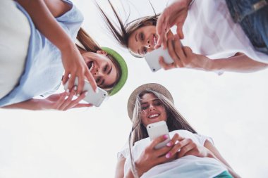 Üç güzel genç kadın şehirde, telefonunuzun ve açık havada yürümek