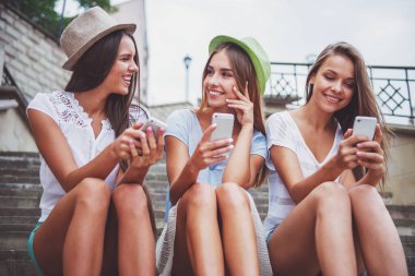 Üç güzel genç kadın şehirde, telefonunuzun ve açık havada yürümek