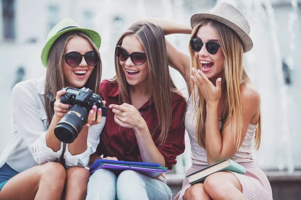 三个年轻貌美的女性走在这座城市 在户外使用相机 — 图库照片