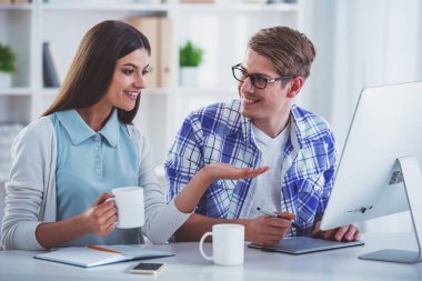 rahat masada oturan ve çalışan genç programcılar giyinmiş.
