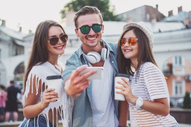 Arkadaşlık, eğlence, teknoloji ve insan kavramı. Gençler selfie Foto, açık havada, kasabada alıyor.