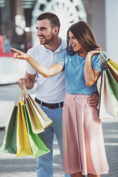 ショッピング バッグを愛する若いカップルを歩いてタウン — ストック写真